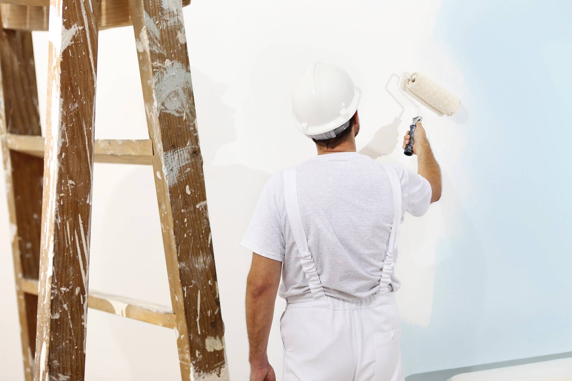 Maler beim sorgfältigen weißen Anstrich einer Wand in Radebeul